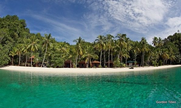 On a pristine beach Triton Bay Divers Resort lies hidden under the coconut trees.